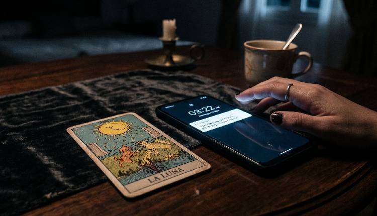 ¿Me es infiel? La tirada de Tarot que destapa los secretos de tu relación 2 Carta de tarot junto a un teléfono móvil en la oscuridad, simbolizando la duda y la búsqueda de respuestas sobre infidelidad en pareja.